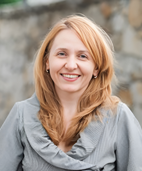 Photo of Ala Gutu, a light red haired woman in a grey sweater