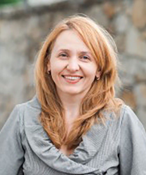 Photo of Ala Gutu, a light red haired woman in a grey sweater