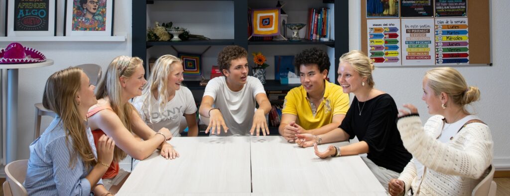 High school students around a classroom table in discussion