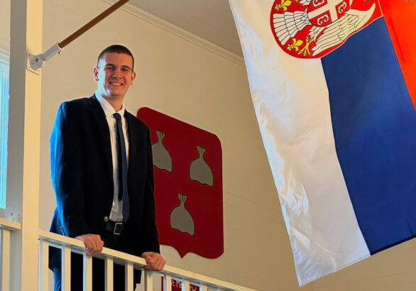 Eo is a male student in a building with school flags